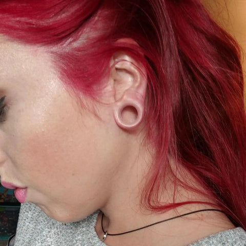 Person wearing Sixteen Millimeter Silicone Flesh Tone Ear Gauges Tunnels Plugs Set With Soft Silicone Double Flare Stretching Kit
