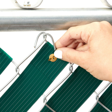 Close-up of hand installing Dark Green PVC Fence Slats For Privacy 1.8 Inch By 246 Feet Privacy Fence Plastic Strips with brass fasteners.