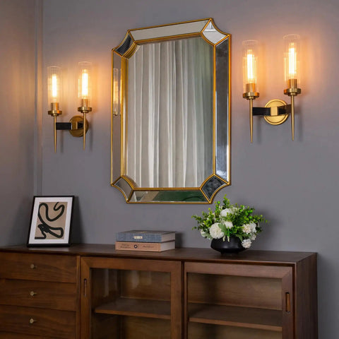 Antique Bronze Two Light Sconce For Bathroom Vanity With Dual Two Point Eight Inch Cylinder Glass Shades beside a mirror
