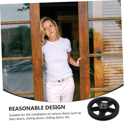Heavy Duty Barn Door Roller Wheel Set Featuring Smooth Steel Casters For Sliding Gates And Windows High Load Rigid Track Hardware Built Like A Tank And Rust Resistant For Effortless Indoor Outdoor Setup, with a close-up view of a roller wheel and a person leaning against a wooden sliding door.