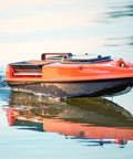 Orange RC boat on water using RC Boat Drive Shaft Kit With 36mm Propeller And Universal Joint, 100mm Shaft, 25mm Sleeve for performance.