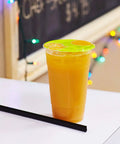 A sealed cup of orange juice using the 95mm PP Sealing Film Roll With Fruit Graphic Design For Sealing Machines, Generic Seal Film.