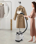 Person using Pro Grade Garment Steamer 110V 1500W with adjustable steam temperature on a beige coat in a modern room.