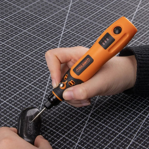 Hands using Mini Cordless Rotary Tool Kit With 3 Speed Settings And 50 Accessories, 3.7V rechargeable rotary tool in orange and black