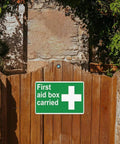 Warning First Aid Box Sign 12x8 Inch Durable Wall Mount Aluminum Sign displayed on a wooden gate outdoors.