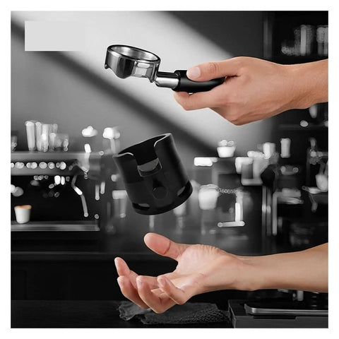 Perfect Your Daily Grind With This Top Shelf Height Adjustable Coffee Tamping Station Built For 58mm Portafilters And Equipped With A Thick Silicone Base, featuring a hand holding a portafilter above a black tamping station.