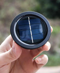 Hand holding a Four Pack Solar Light Replacement Top For Outdoor Lanterns, Waterproof And All Weather, 2.76 Inch Lid, black finish.