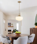 Lumraxsun Vintage Pendant Light Over Kitchen Glass Kitchen Pendant Light hanging over a round dining table with gray chairs.
