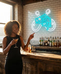 Smiling woman pointing at Ice Blue Crossed Fish Hook Neon Sign LED Light Dimmable Wall Decor in a cozy bar setting