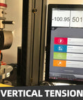 Vertical tension testing rig with metal clamp and hanging ring; computer monitor displays measurement readouts.