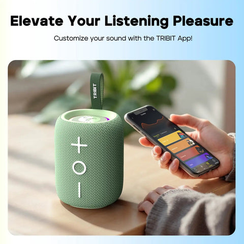 Green StormBox Mini Plus Portable Bluetooth Speaker With 360 Surround Sound, 12W Output, IPX7 Waterproof next to a smartphone.