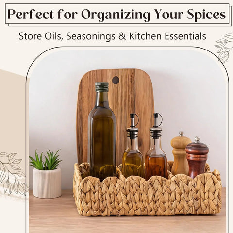 Wicker basket with bottles and spices on a countertop, decorative plant and cutting board in background.