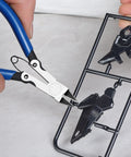 Precision Flush Cutters And Wire Cutters For Electronics And DIY Projects trimming sprue with blue handles and steel jaws.