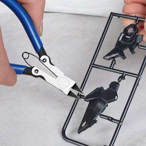 Precision Flush Cutters And Wire Cutters For Electronics And DIY Projects trimming sprue with blue handles and steel jaws.
