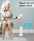 Tall Free Standing Toilet Paper Holder With Marble Base For Easy Reach No Bending Needed 29 And A Half Inch Bathroom Roll Stand In Brushed SUS304 Stainless Steel Elder Friendly Durable Modern Bath Accessory displayed beside a person reaching easily.