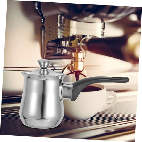 Turkish Teapot 180ml Milk Frothing Pot Stainless Steel Induction Coffee Pot next to a coffee machine for quick brews.