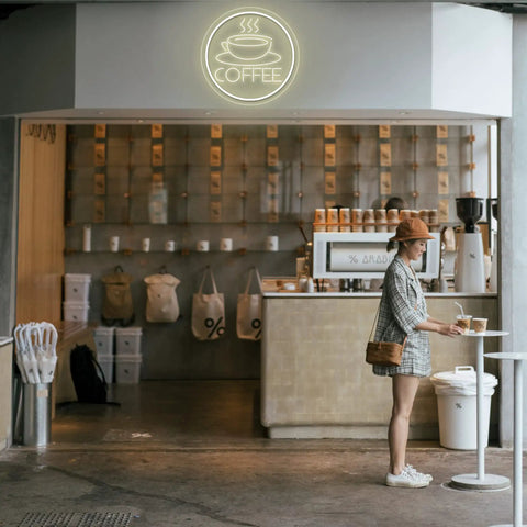 Coffee Cup Neon Sign USB Powered LED Light With 3D Engraved Art for cafe wall decor, glowing above a customer at a coffee bar.