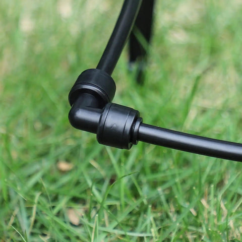 Close-up of One Quarter Inch Drip Irrigation Elbow Coupling Connector Quick Connect Garden Hose Elbow Connector on grass
