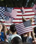 Handheld 5x8 Inch American Flags on Wooden Sticks 12 Pack in a crowd at a patriotic event, small US flags waving with safe spear tops.