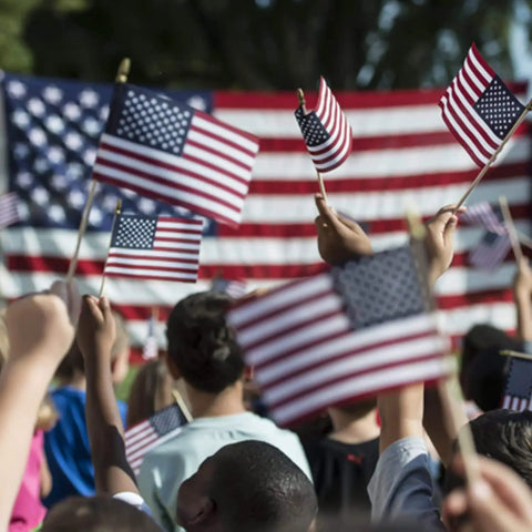 Handheld 5x8 Inch American Flags on Wooden Sticks 12 Pack in a crowd at a patriotic event, small US flags waving with safe spear tops.