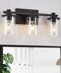 Three Light Black Vanity Light With Clear Glass Shade For Bathroom Living Room Hallway And Bedroom Slick Waterproof Metal Sconce With Modern Vintage Style Fixture, shown mounted above a mirror.