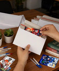 Person using 110 Pack White Trading Card Shipping Envelopes 7x4.35 Inch Self Adhesive Mailers For Semi-Rigid Sleeves