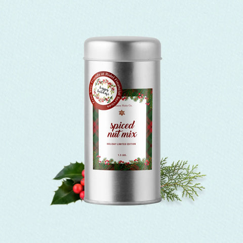 Spiced nut mix in a silver tin, 1.5 lbs, holiday limited edition, with festive decorations on a light background.