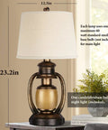 Rustic Lantern Table Lamp For Living Room And Bedroom End Table With Oatmeal Tapered Drum Shade next to potted plant