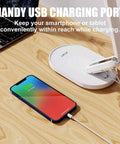 Eye Care Desk Lamp With USB Charging Port Dimmable 5 Color Modes And 72 LED Full Spectrum Touch Control And Memory Function No Flicker Office Table Light For Reading And Studying shown with charging smartphone on a wooden desk