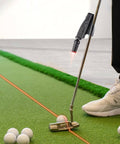 Indoor Golf Laser Putting Training Aid With Dual Modes For Alignment And Stroke Feedback attached to putter on green mat