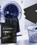 Black Fabric Dye Sheets 10 Pack That Restores Faded Clothes To Rich Black In Every Wash next to laundry machine and basket.