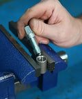 Hand using Rethreading Tap 1/4-20NC Thread Repair Tool Set For Damaged Bolt Threads in blue metal vice, showing precision restoration