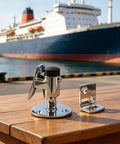 Heavy Duty Marine Grade 316 Stainless Steel Door Holder Catch With Rubber Bumper To Stop Slamming Noise And Keep Your RV Or Yacht Door Securely Locked In Place Without Rusting In Saltwater Conditions, displayed on a wooden table with a ship in the background.