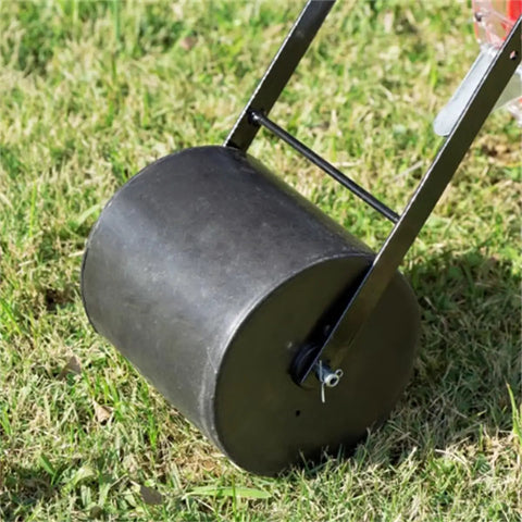 Close-up of Hands On Roller Seeder For Easy Planting No Bend Planting Semi Automatic Metal Garden Seeder on grass