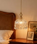 Top Shelf Vintage Crystal Pendant Light With Dope Diamond Cut Glass Shade And Legit Brass Accents Adjustable 0.5 To 70 Inch Cord above a bedside table.