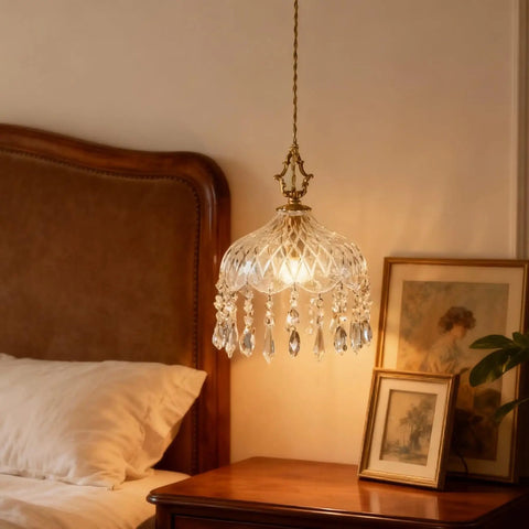 Top Shelf Vintage Crystal Pendant Light With Dope Diamond Cut Glass Shade And Legit Brass Accents Adjustable 0.5 To 70 Inch Cord above a bedside table.