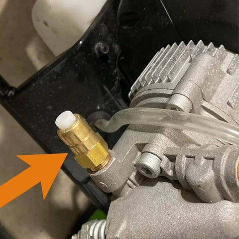 Brass thermal relief valve with white plastic cap on a pressure washer pump, attached clear hose.