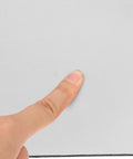 Close-up of a finger touching the texture of the White Sublimation Mouse Pad for Heat Press Transfers, 8.7x7.1 Inch Blank Desk Pad.
