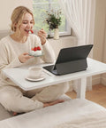 Total Game Changer Over Bed Table With Smooth Rolling Casters And No Sweat Pneumatic Height Adjustment Super Spacious Work Surface for cozy dining on a couch.