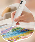 Badass Cordless Electric Pickup Pen With Reliable Vacuum Grip To Snag Loose Bits Zero Sweat For Desk Projects Plus Bright Light And Smooth Angled Tip For Crisp Workflows in hand, picking up colorful beads.