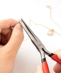 Using 6 Inch Needle Nose Pliers With Extra Long Tapering Non Serrated Jaws For Jewelry Making, gripping gold chain close-up.