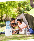 Go-To Mini Desktop Cold Water Dispenser With Built In Tap used outdoors near a tent with a family enjoying a picnic.