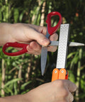 Person using Folding Pocket Diamond Sharpener For Garden Tools And Knives, Dual Sided 400 600 Grit Stone For Scissors outdoors