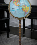 Globe on turned wood stand with brass-toned metal base, 12-inch globe showing Americas.