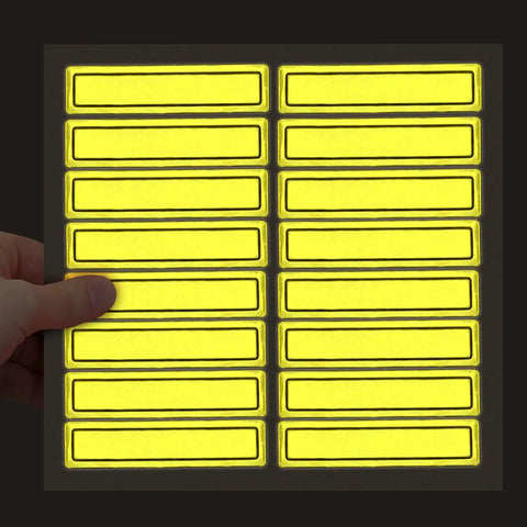 Hand holding sheet of Yellow Retro Reflective Hard Hat Stickers 1 By 4 Inch Pack Of 16 Durable Helmet Decals for safety