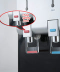 Close-up of Desktop Water Cooler Dispenser With Hot And Cold Water Top Loading Child Safety Lock, focus on hot and cold faucets.