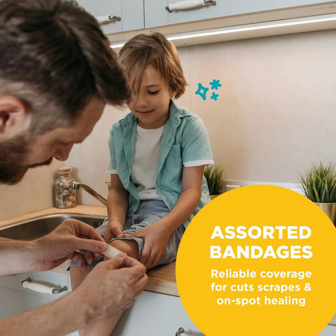 Front view: Be Smart Get Prepared 110-pc First Aid Kit used as man applies bandage to child's knee on kitchen counter.