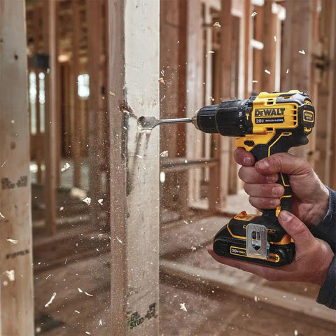 Person using Atomic 20V Max Cordless Hammer Drill With 1/2 Inch Chuck on wood, demonstrating its compact design and LED foot light.