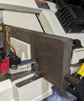 Close-up of 9 Inch Metal Horizontal Band Saw With 9x12 Inch Rectangular Cutting Capacity cutting metal, focus on blade and feed system.