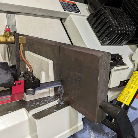 Close-up of 9 Inch Metal Horizontal Band Saw With 9x12 Inch Rectangular Cutting Capacity cutting metal, focus on blade and feed system.